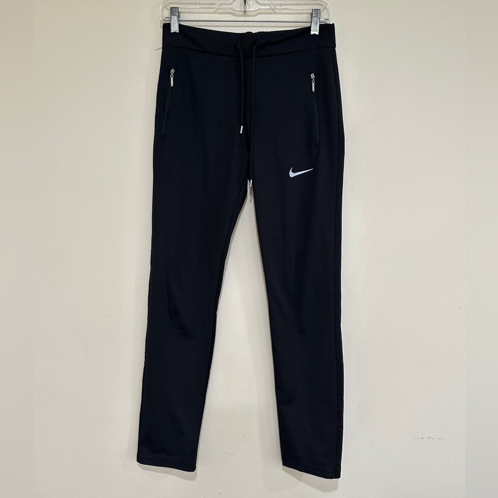 Women’s Nike black track pants With zip pockets and tie waist. Size M